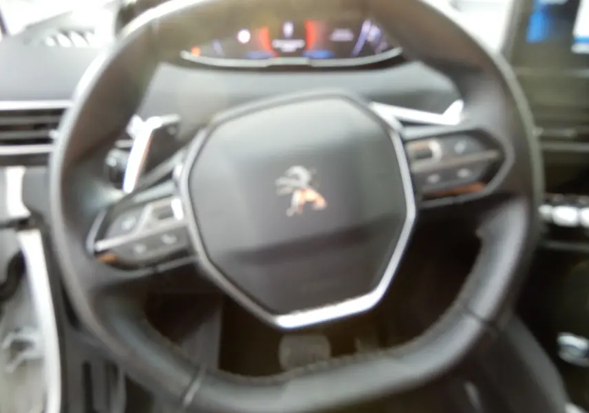 Vue rapprochée du volant cuir noir du Peugeot 5008 BlueHDi 130 Allure 2021 avec commandes intégrées.