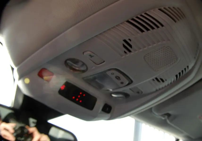 Vue en gros plan du plafonnier intérieur gris clair du Peugeot 5008 blanc nacré, avec commandes et éclairage LED.