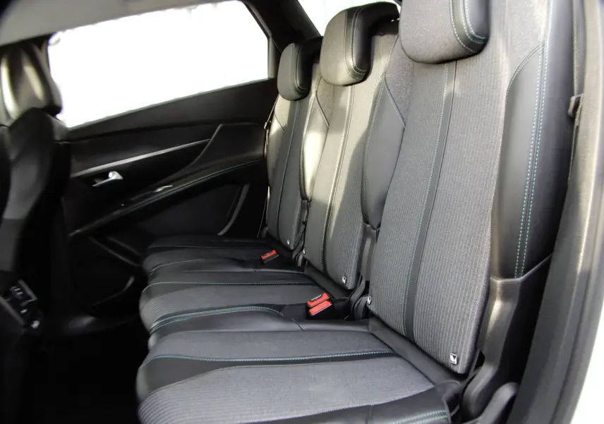 Vue latérale des sièges arrière noirs avec surpiqûres bleues du Peugeot 5008 blanc nacré 2021 version BlueHDi 130 Allure.