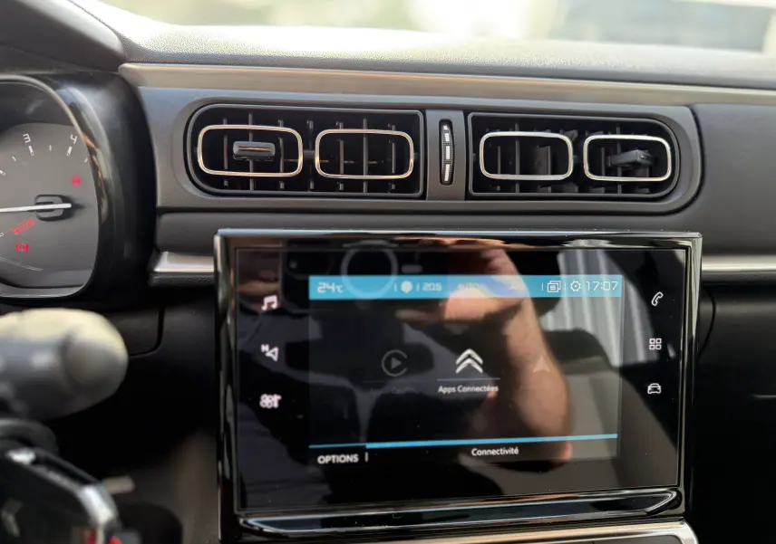 Tableau de bord intérieur de Citroën C3 gris acier 2023, vue centrée sur l'écran tactile et les aérateurs rectangulaires.