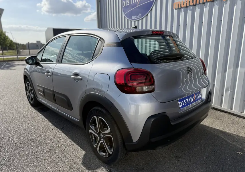 Citroën C3 gris acier vue 3/4 arrière droit, avec protections latérales noires et jantes originales.