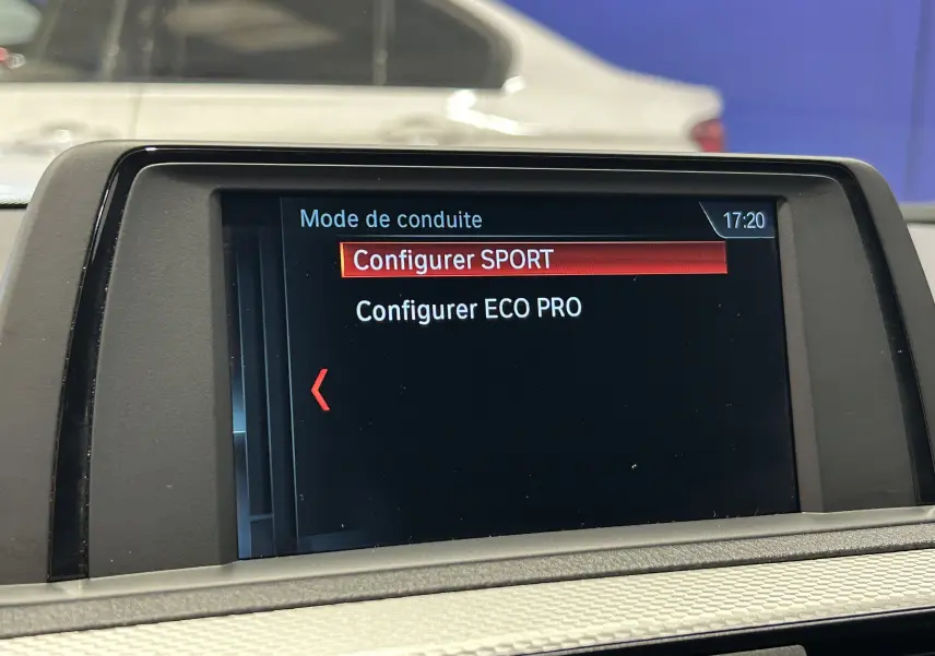 Écran central de BMW Série 1 120iA blanc 2019 montrant le menu de configuration des modes de conduite Sport et Eco Pro.