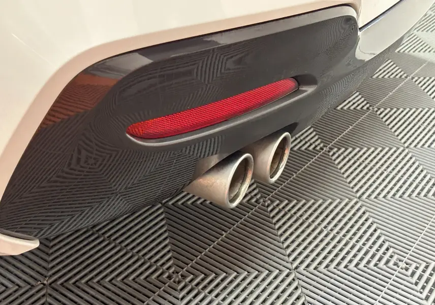 Gros plan sur la double sortie d'échappement arrière droite d'une BMW Série 1 blanche M Sport de 2019.