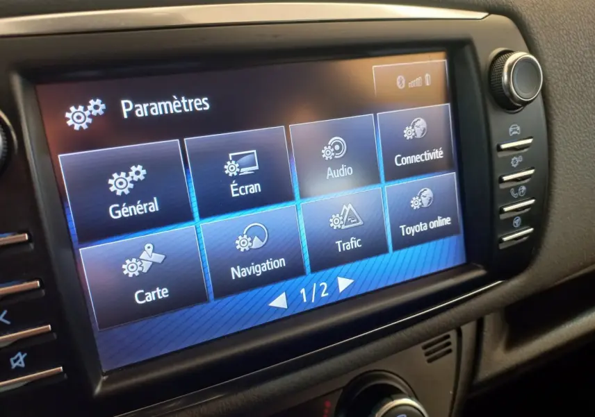 Écran tactile central de la Toyota Yaris hybride 2018 affichant le menu des paramètres en intérieur noir.