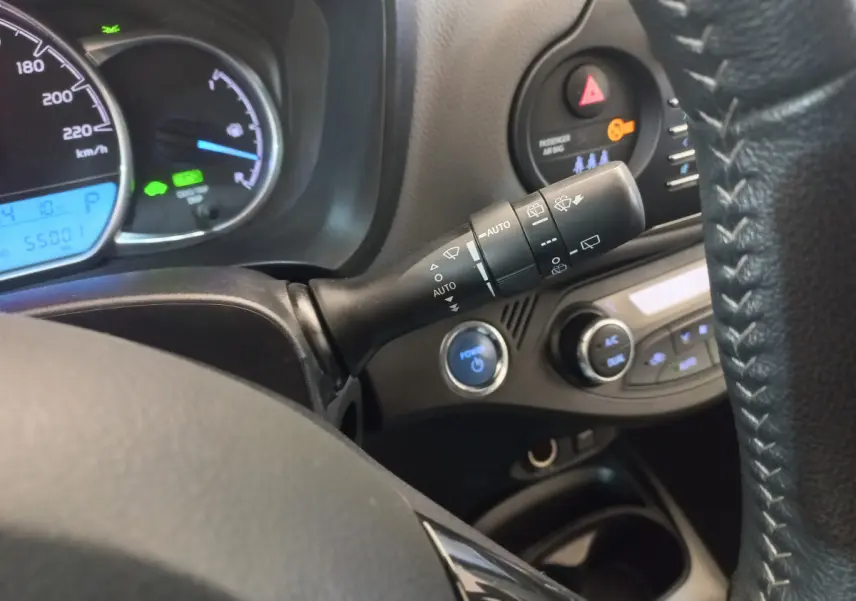 Gros plan intérieur sur la commande d’essuie-glace et tableau de bord de la Toyota Yaris hybride noire de 2018.