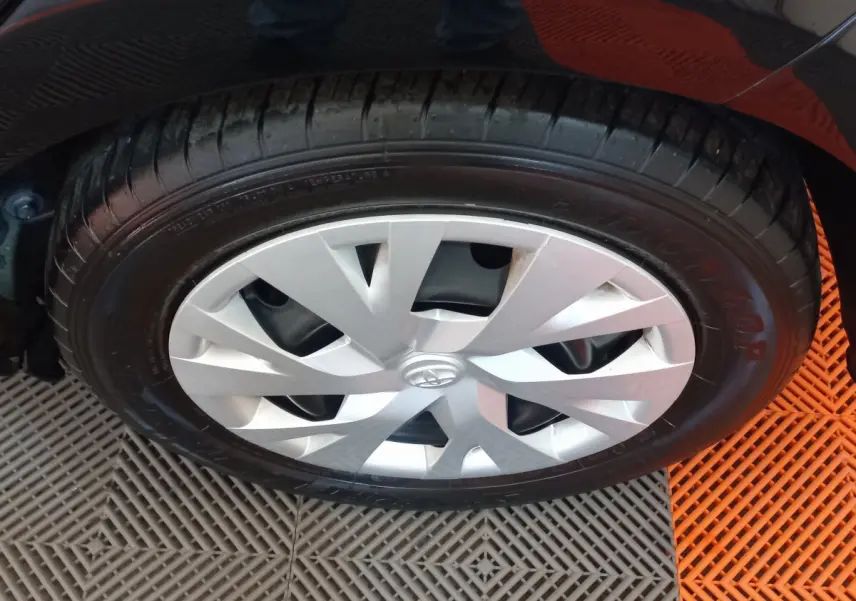 Gros plan sur la roue avant droite de la Toyota Yaris noire, mettant en valeur la jante argentée au design moderne.