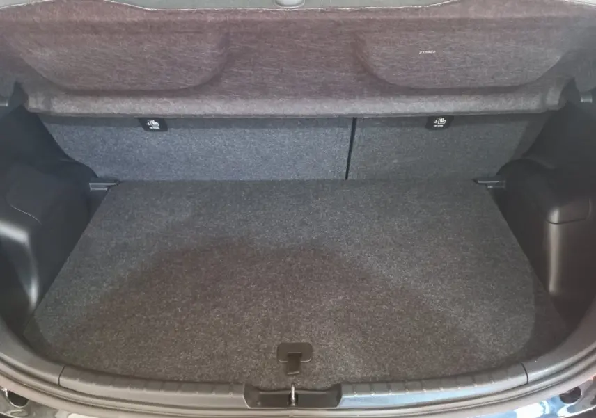 Coffre ouvert vu de face d'une Toyota Yaris noire, montrant un espace de chargement propre et spacieux.