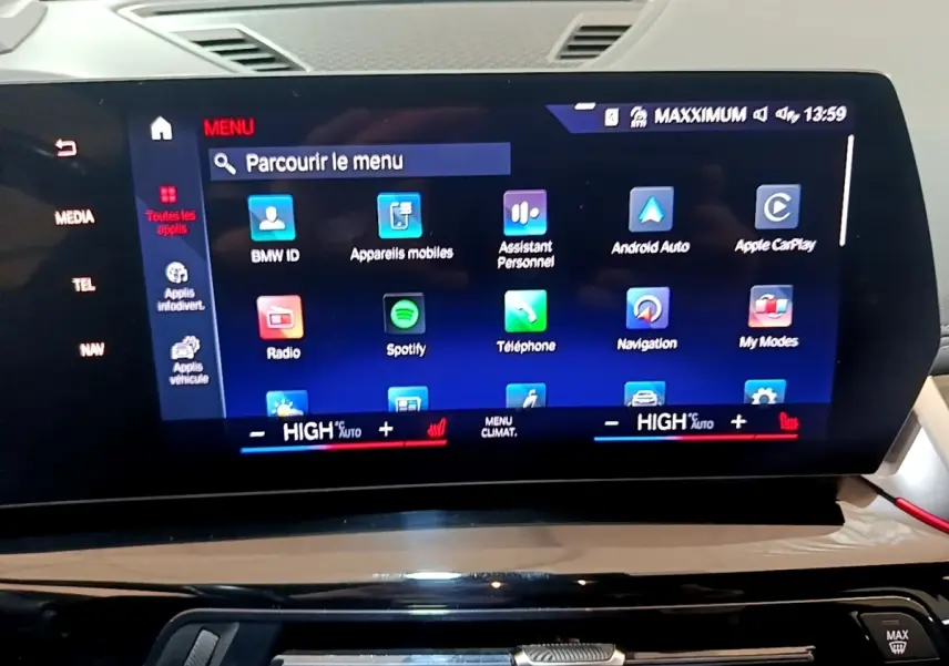 Écran tactile central du tableau de bord du BMW X1 gris clair, affichant le menu multimédia et navigation.
