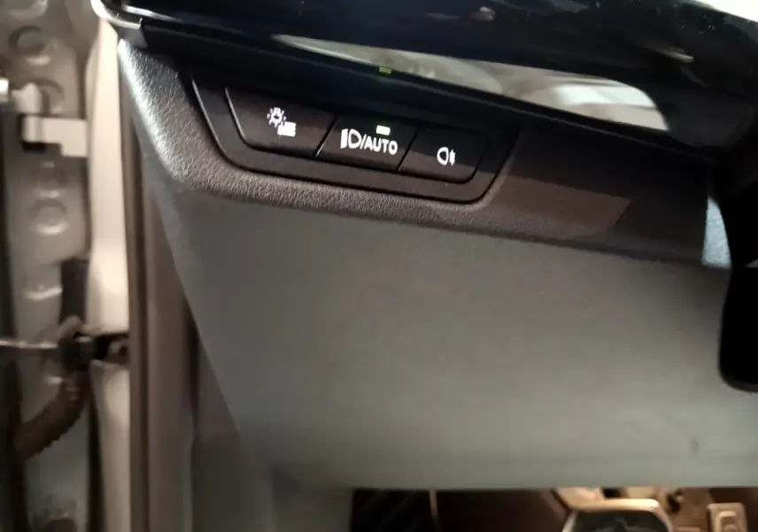 Détail du tableau de bord côté gauche avec commandes d’éclairage sur BMW X1 xDrive23i M Sport gris clair 2023.