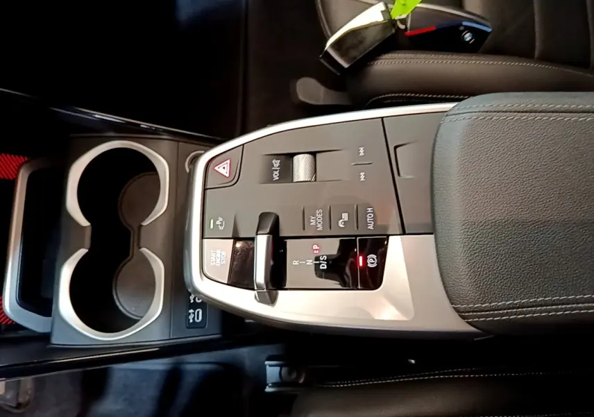 Gros plan sur la console centrale grise et noire du BMW X1 xDrive23i M Sport 2023 avec levier de vitesses et commandes tactiles.