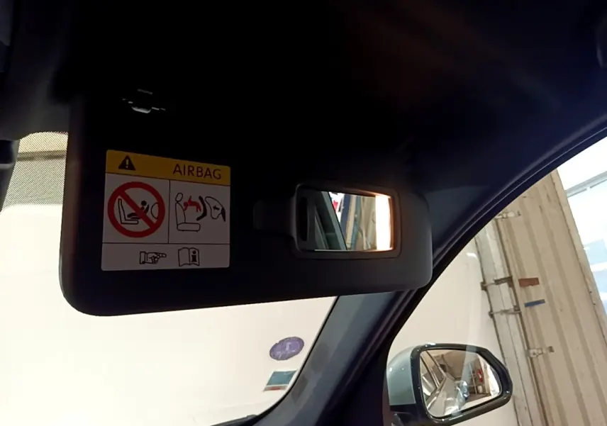 Vue intérieure côté conducteur du pare-soleil avec miroir éclairé et rétroviseur extérieur gris clair d’un BMW X1 2023.