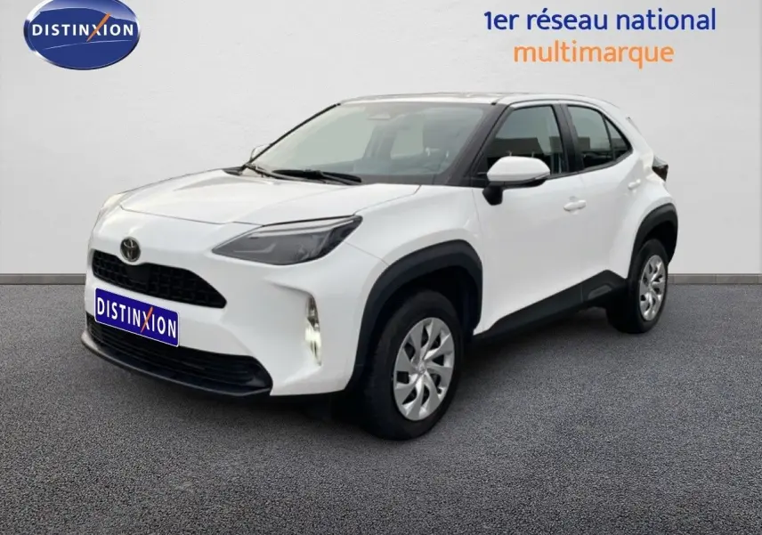 Toyota Yaris Cross blanc pur en 3/4 avant droit, avec calandre noire et protections d'ailes noires.