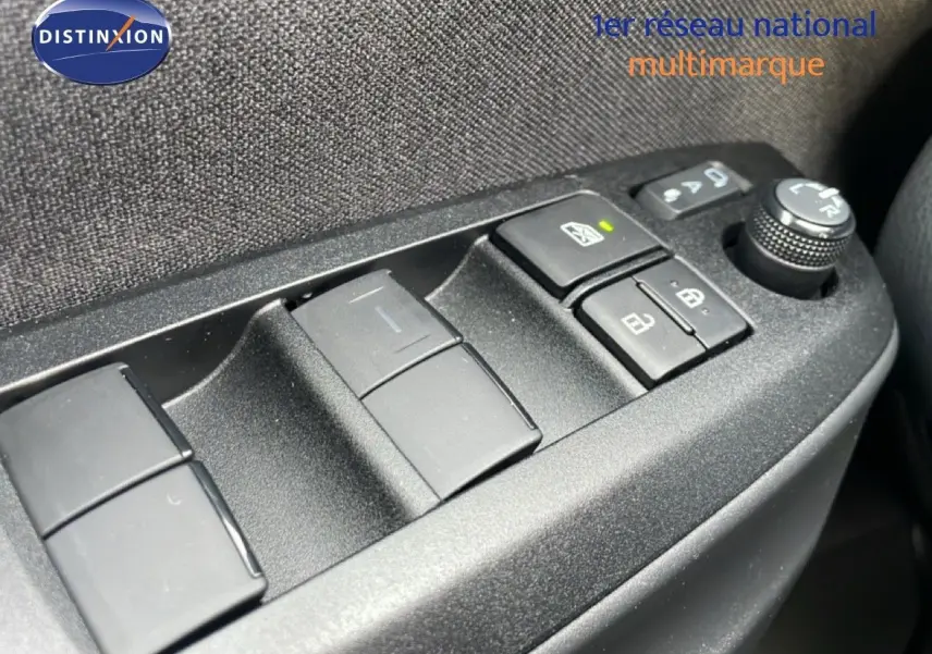 Gros plan sur les commandes de lève-vitres et réglage des rétroviseurs côté conducteur d'une Toyota Yaris Cross blanc pur 2024.