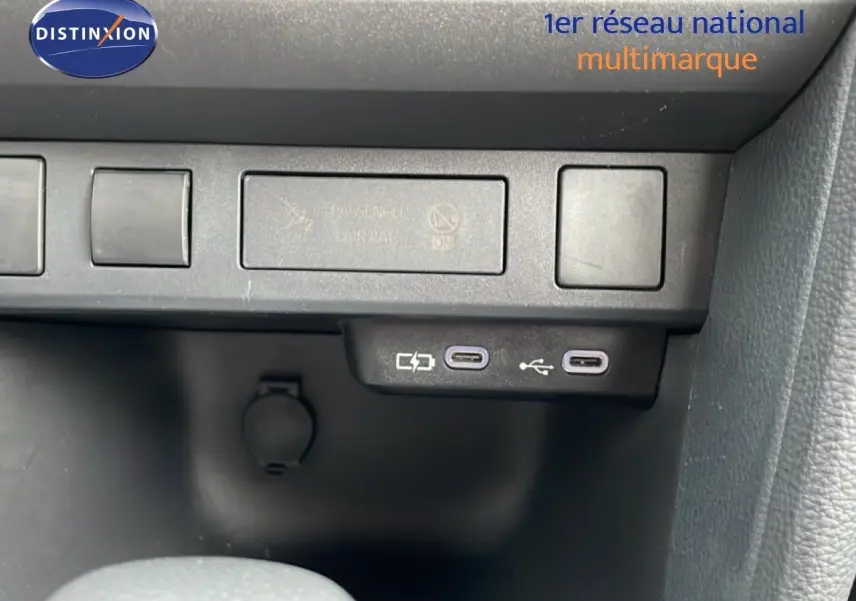 Détail du tableau de bord de la Toyota Yaris Cross 2024, montrant les ports USB-C et les boutons de commande en plastique noir.