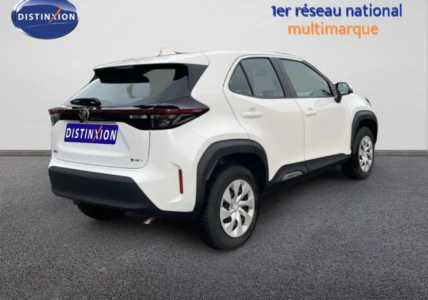 Vue 3/4 arrière droite d'une Toyota Yaris Cross blanche avec toit noir et feux arrière étirés en bandeau.