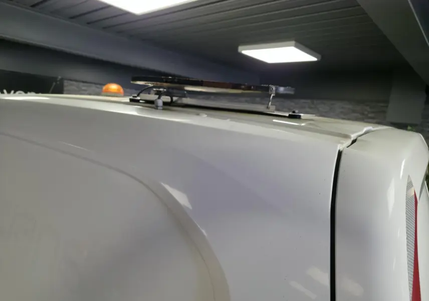 Vue rapprochée du toit blanc du Peugeot Partner 2021 avec son gyrophare orange et l'antenne de toit visible.