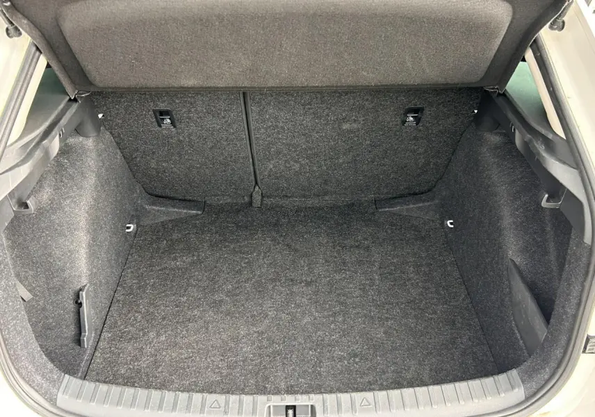 Coffre ouvert vu de face d'une Skoda Scala blanc Candy, montrant l'espace de chargement intérieur vide et tapissé.