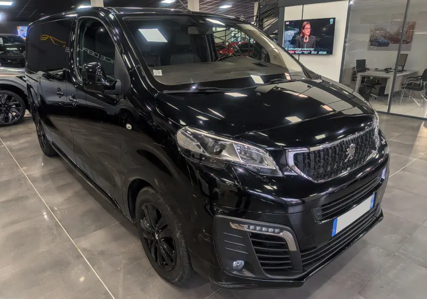 Vue 3/4 avant droit d’un Peugeot Expert Fourgon noir Perla avec calandre noire et jantes assorties en showroom.