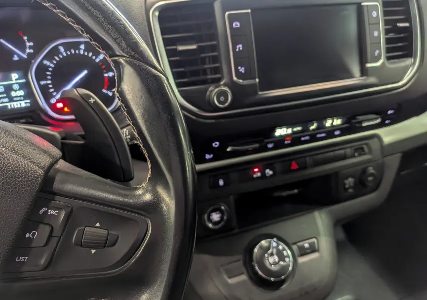 Vue rapprochée de l’intérieur du Peugeot Expert Fourgon noir, montrant le volant, tableau de bord et écran tactile central.