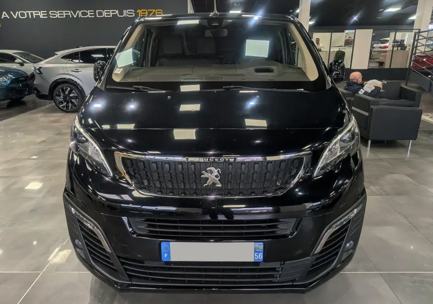 Vue de face d’un Peugeot Expert Fourgon noir Perla, mettant en valeur sa calandre chromée et ses phares modernes en showroom.