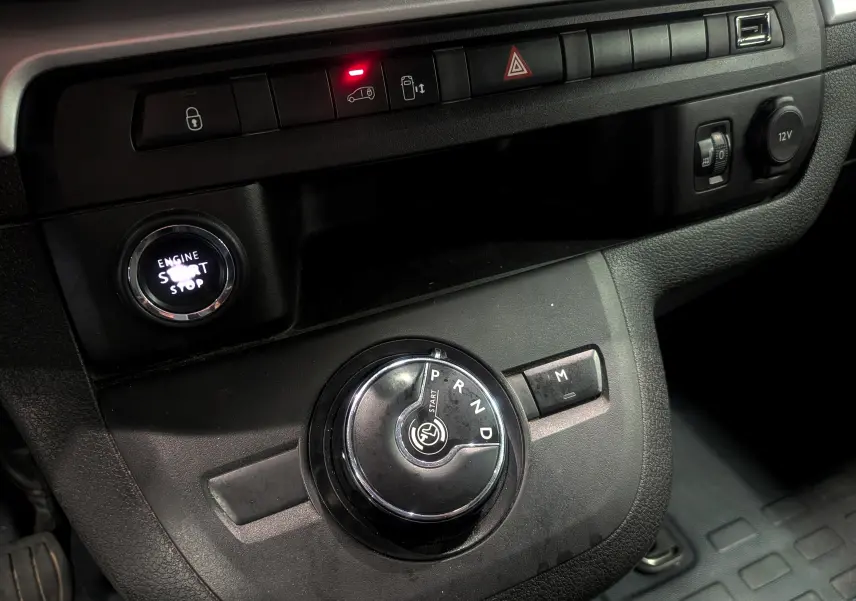 Gros plan sur la console centrale noire du Peugeot Expert Fourgon 2020, avec bouton start/stop et sélecteur de boîte auto circulaire.
