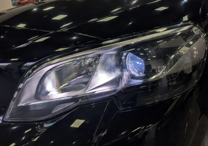Gros plan sur le phare avant droit du Peugeot Expert Fourgon noir Perla, mettant en valeur son design moderne et lumineux.