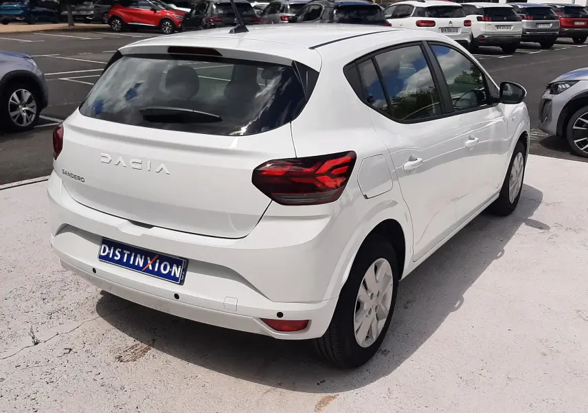 Vue 3/4 arrière droite d'une Dacia Sandero blanc glacier 2024, avec feux arrière LED et cinq portes visibles.