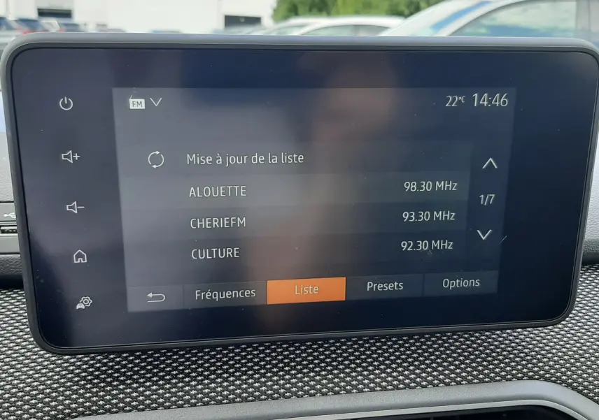 Écran tactile central du tableau de bord de la Dacia Sandero 2024 affichant la liste des stations radio FM.
