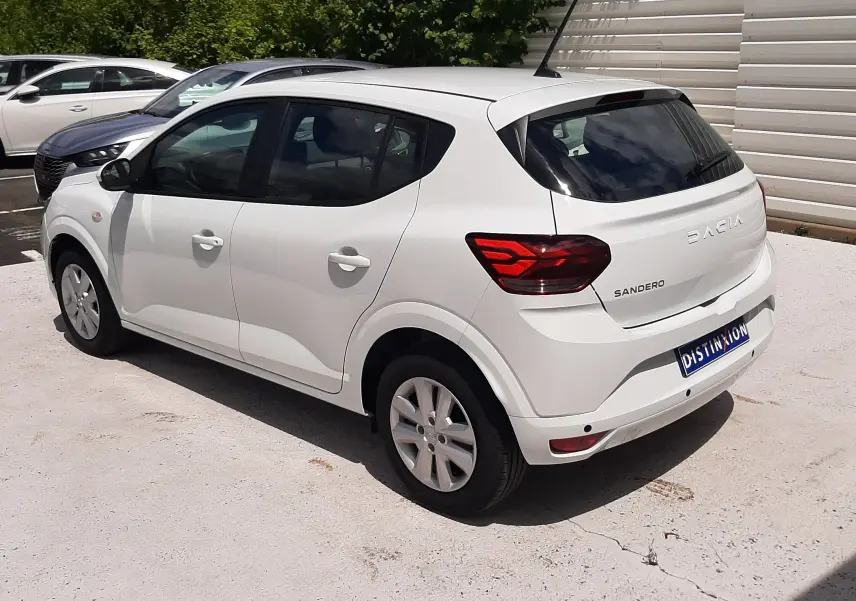 Vue 3/4 arrière droite d'une Dacia Sandero blanc glacier 2024 avec feux arrière LED et vitres teintées.