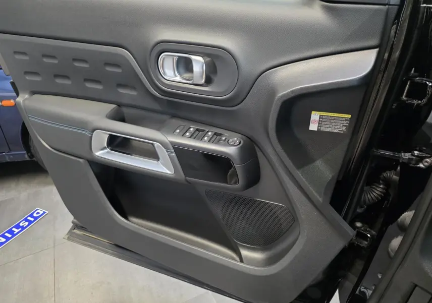 Vue intérieure côté gauche de la porte noire métallisée du Citroën C5 Aircross avec commandes de vitres et poignée argentée.