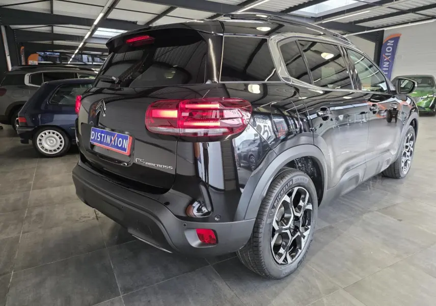 Vue 3/4 arrière droite du Citroën C5 Aircross noir métal avec jantes alliage bi-ton et feux arrière LED 3D allumés.