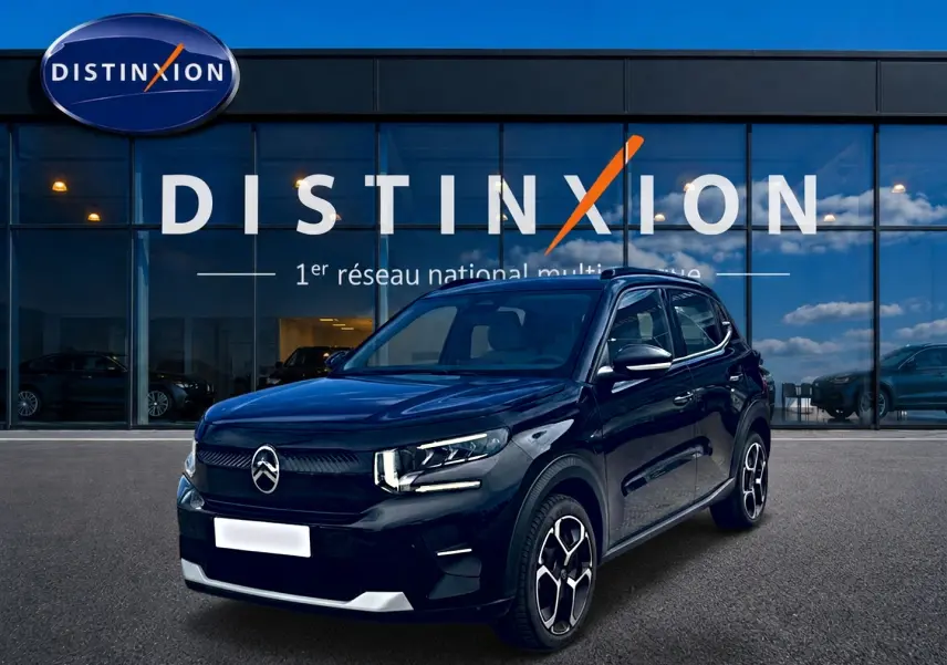 Citroën C3 113 Plus électrique noire vue 3/4 avant, avec jantes distinctives et calandre épurée devant showroom Distinxion.