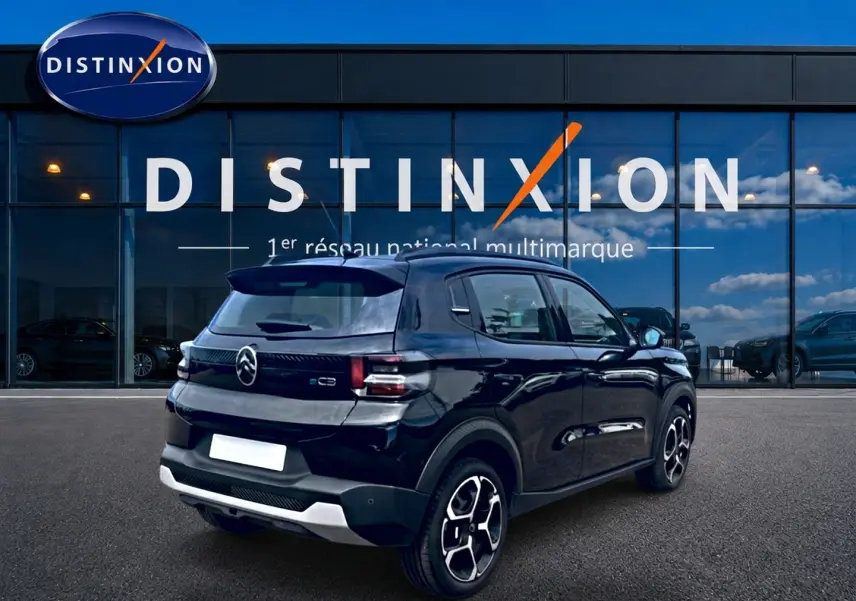 Citroën C3 113 Plus électrique noire vue 3/4 arrière droit, avec jantes distinctives et toit noir brillant.
