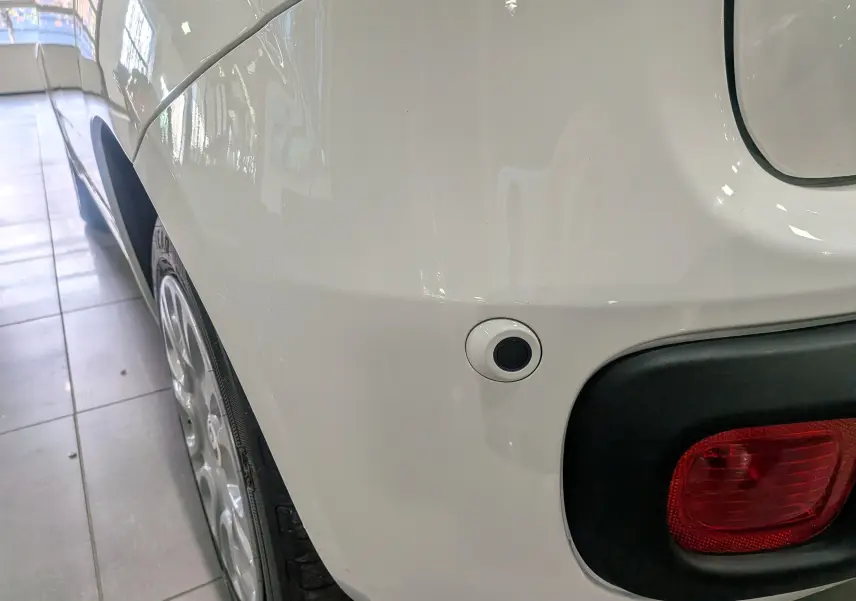 Gros plan sur l'arrière droit blanc gelato d'une Fiat Panda 1.0 Hybrid 2025 avec feu rouge et capteur de recul.