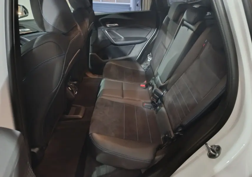 Vue intérieure côté droit des sièges arrière en cuir noir du BMW X1 xDrive25e M Sport blanc de 2024.