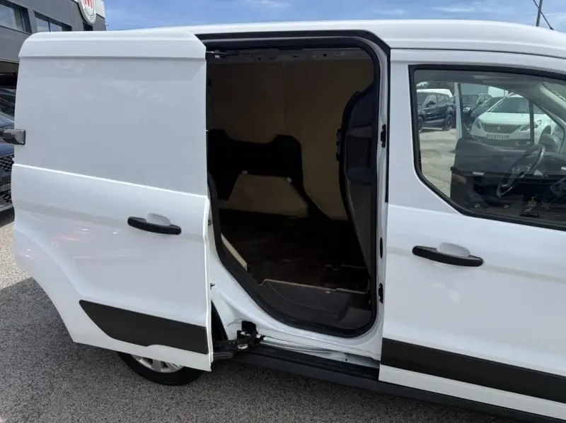 Vue latérale droite d’un Ford Transit Connect blanc glacier avec porte coulissante ouverte montrant l’espace de chargement vide.