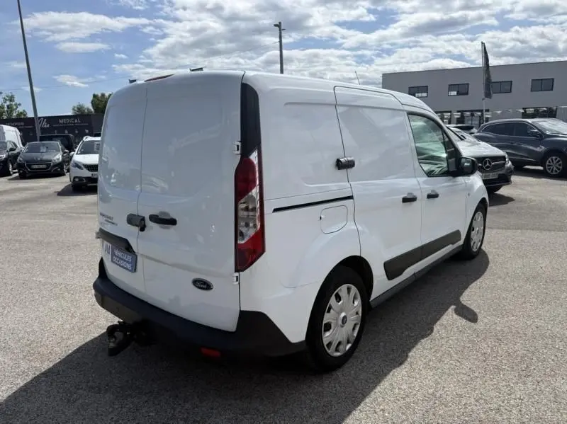 Vue 3/4 arrière droite d’un Ford Transit Connect blanc glacier, fourgon utilitaire avec attelage et vitres latérales opaques.