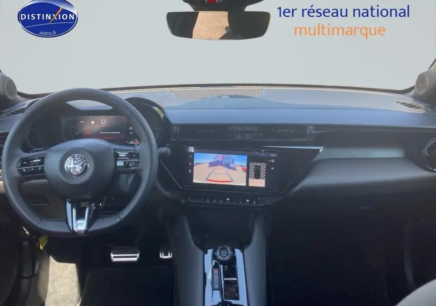 Vue intérieure avant de l'Alfa Romeo Junior 1.2 hybride ivoire/noir, avec écran tactile et volant multifonction.