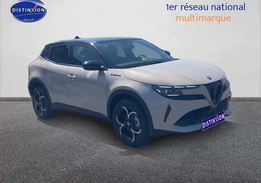 Alfa Romeo Junior 1.2 hybride 2026 en 3/4 avant, couleur ivoire et toit noir avec jantes en alliage distinctives.