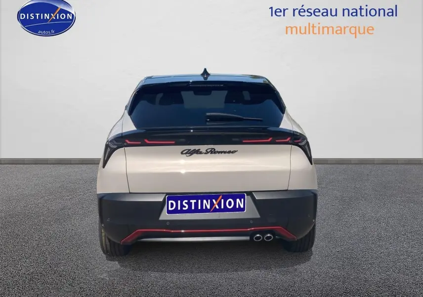 Vue arrière d'une Alfa Romeo Junior 1.2 hybride ivoire et noir avec feux LED et double sortie d'échappement visible.