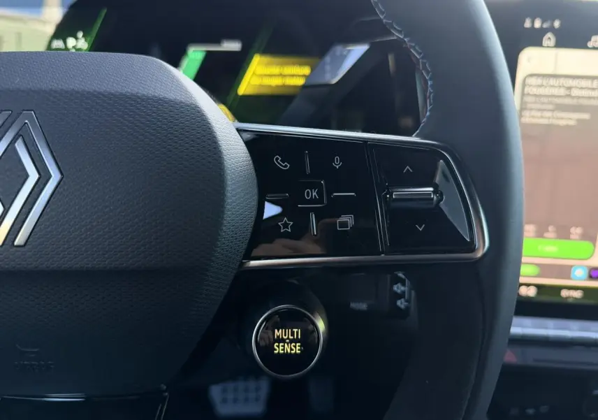 Gros plan sur le volant noir avec surpiqûres bleues et bouton Multi-Sense du Renault Rafale E-Tech hybride 2026.
