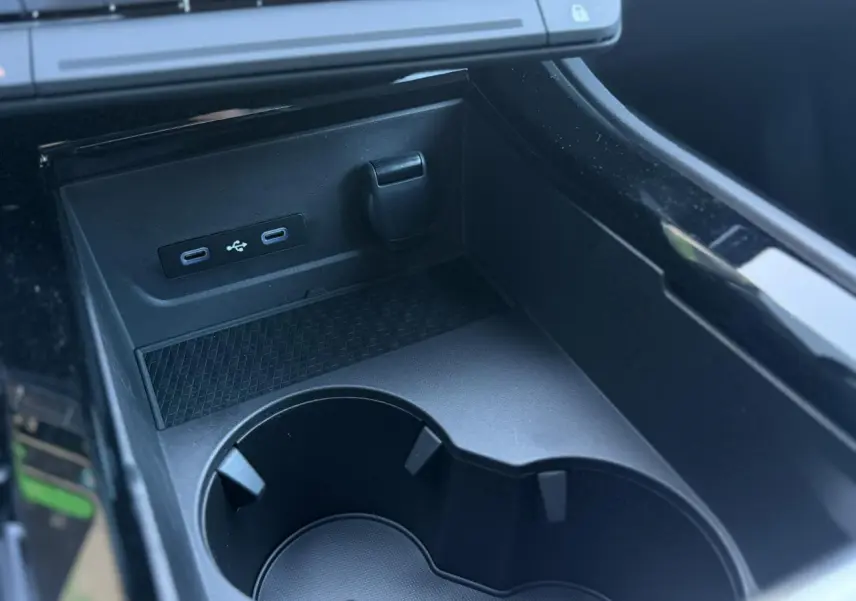 Gros plan sur la console centrale noire du Renault Rafale avec ports USB-C et prise 12V, porte-gobelets intégrés.