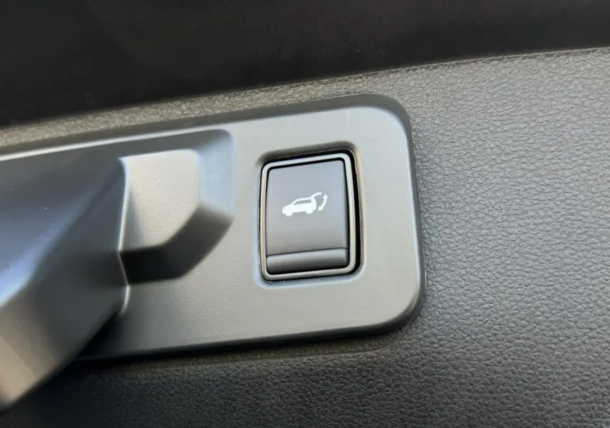 Bouton d'ouverture électrique du hayon sur panneau intérieur noir du Renault Rafale E-Tech Gris Schiste.
