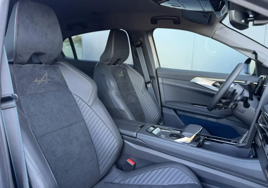 Vue intérieure côté conducteur de la Renault Rafale E-Tech gris avec sièges sport Alcantara et surpiqûres tricolores.