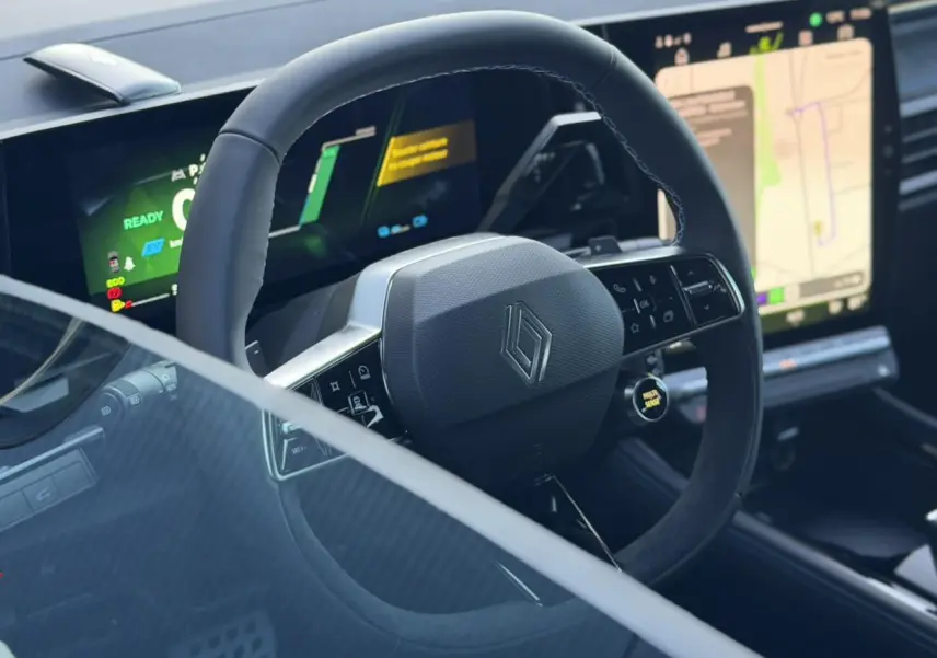 Vue rapprochée du volant Alcantara avec logo Renault et tableau de bord numérique du Renault Rafale E-Tech 2026.