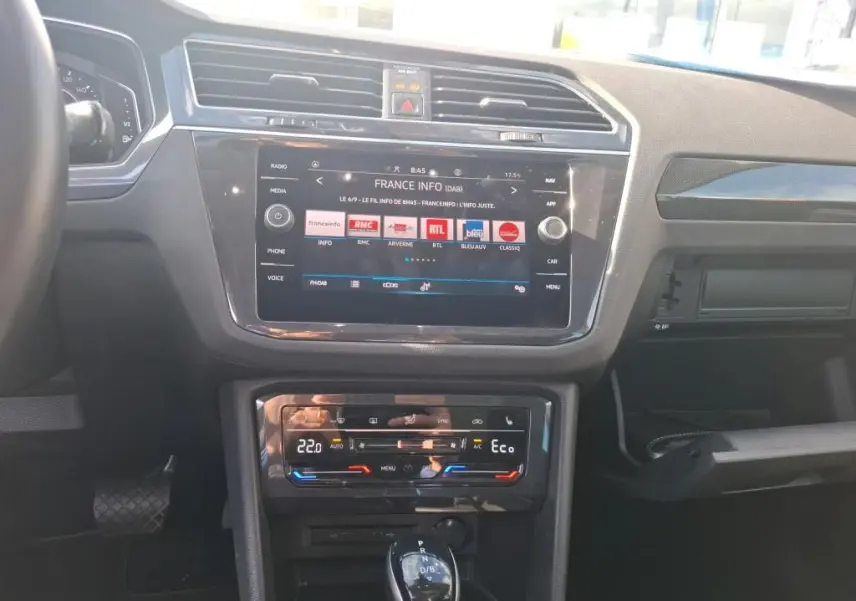 Vue intérieure du tableau de bord du Volkswagen Tiguan 1.4 e-Hybrid 2022 avec écran tactile et commandes climatisation digitales.