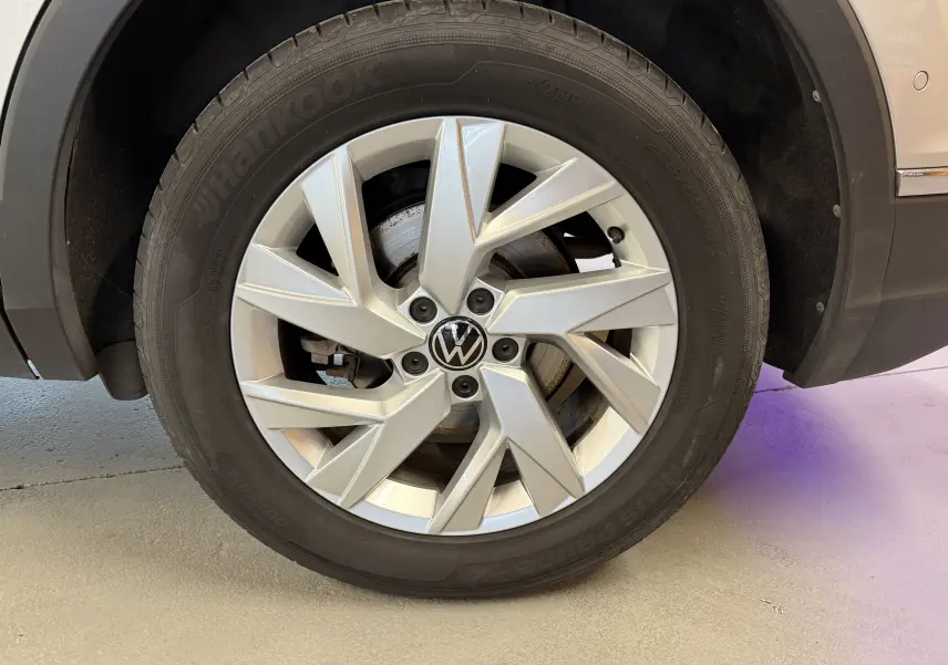 Gros plan sur la roue avant droite d’un Volkswagen Tiguan gris clair, mettant en valeur la jante alliage et le pneu Hankook.