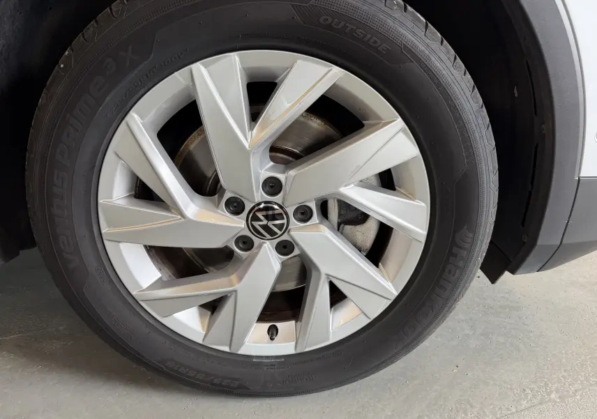 Gros plan sur la roue avant droite du Volkswagen Tiguan gris clair, mettant en valeur la jante alliage et le pneu Hankook.