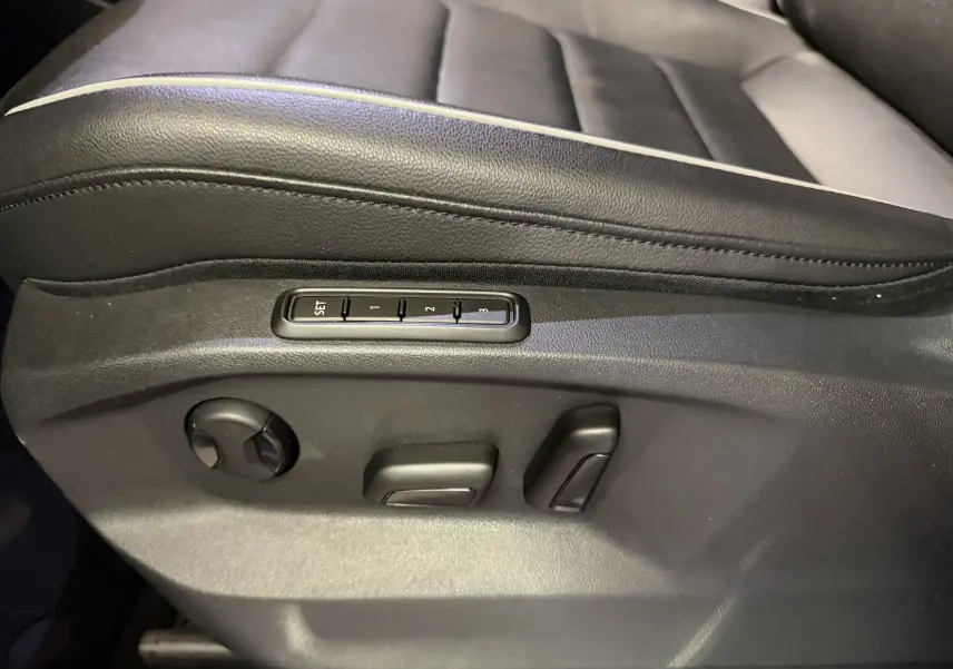 Détail des commandes de réglage électrique du siège conducteur en tissu noir du Volkswagen Tiguan 1.4 E-HYBRID 2022.