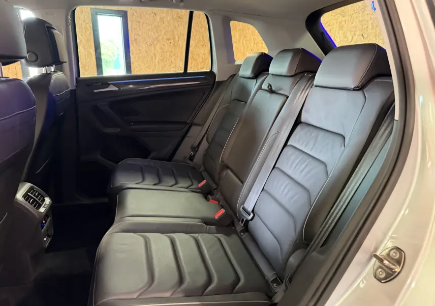 Vue intérieure côté droit des sièges arrière en cuir noir du Volkswagen Tiguan gris clair 2022, version hybride rechargeable.